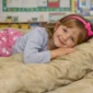 Child using sensory ball blanket in classroom setting