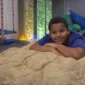 Child resting on sensory ball blanket in therapy room