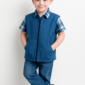 boy wearing blue vest in white studio room