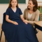 Child using a navy weighted blanket in a classroom with adult support.