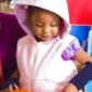 Child wearing a pink hooded weighted sensory vest while playing with blocks.